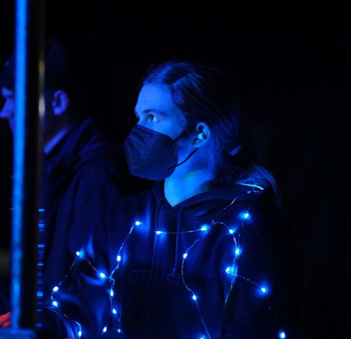 Frau im schwarzen Pullover mit integrierter Lichterkette